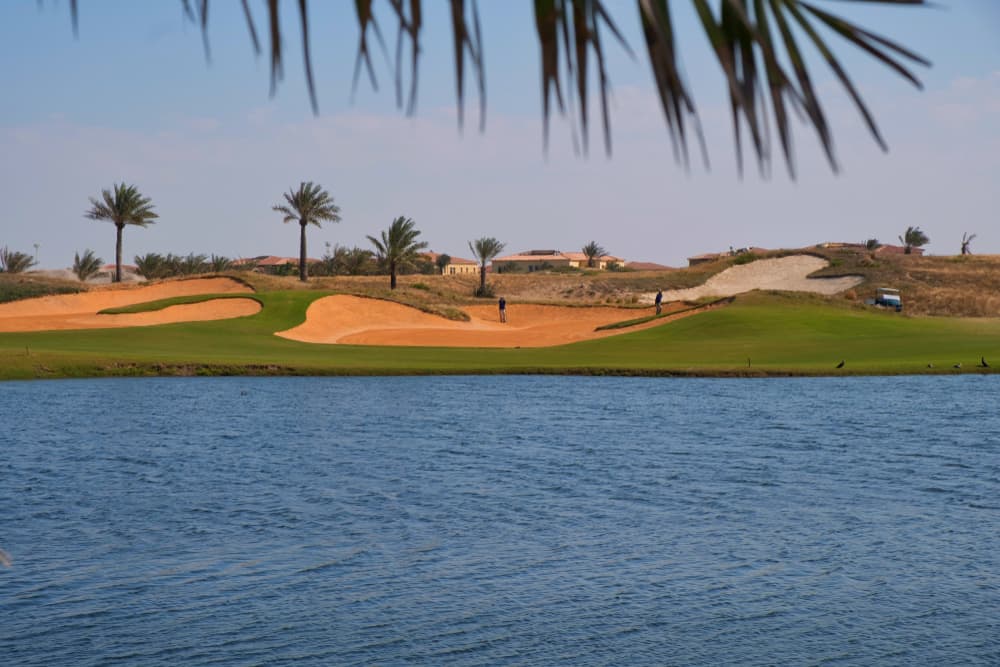 The green fairways and sand bunkers of Saadiyat Beach Golf Club beside the water